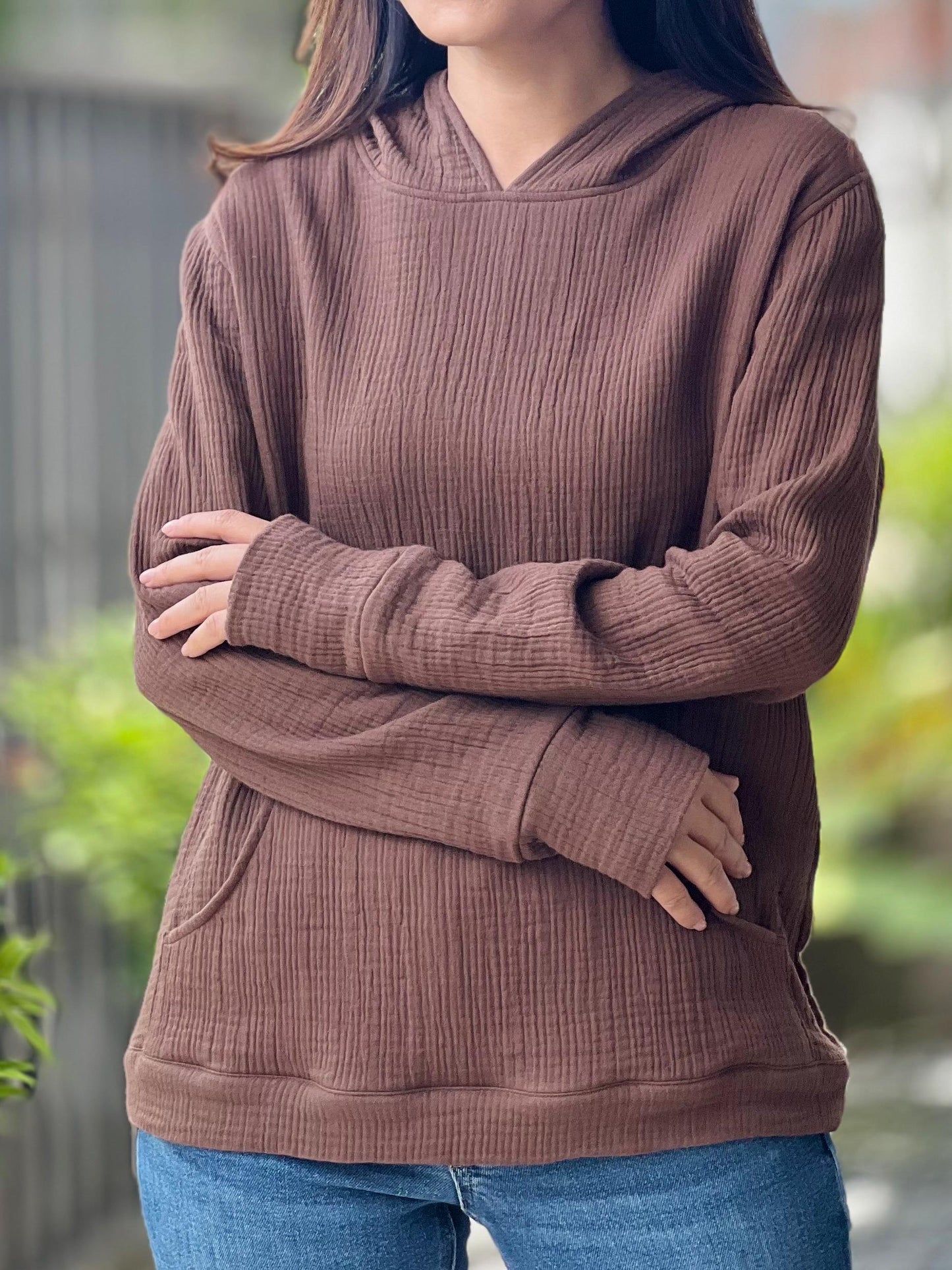 May include: A brown waffle knit hooded sweatshirt with a kangaroo pocket.